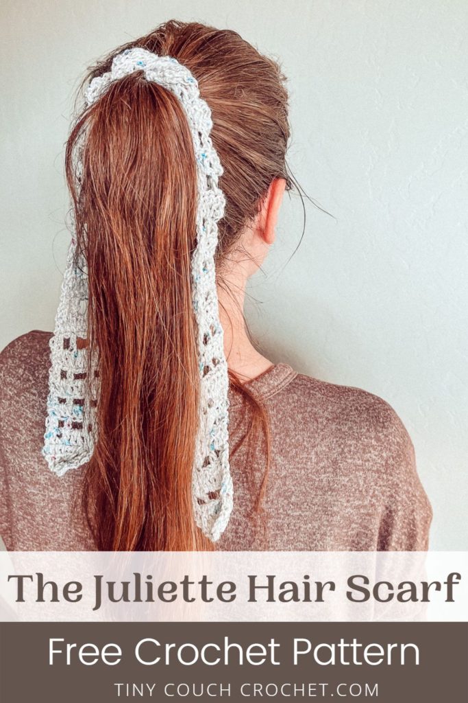 A woman is facing away from the camera, with long brown hair in a pony tail. A crocheted hair scarf is tied around the ponytail and hanging down either side. The background is white. The bottom of the image says "The Juliette Hair Scarf Free Crochet Pattern Tinycouchcrochet.com"